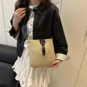 Handwoven straw crossbody bag with black leather flap and gold hardware for summer beach vacation