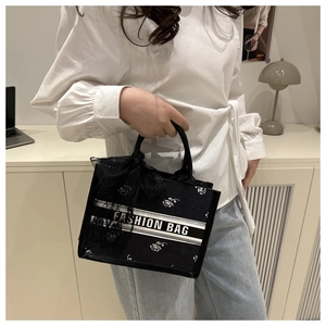 Detailed macro view of floral canvas tote bag with silk bow and fashion logo handle