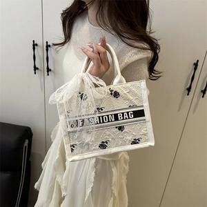 Elegant white tote bag with black floral patterns and lace bow for women's daily commute