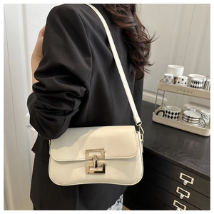 Close-up of off-white baguette bag featuring a geometric gold buckle and soft PU leather