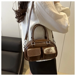 Brown patent leather baguette bag with dual front pockets shown on female model