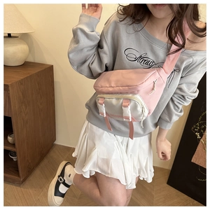 Pink and white contrast nylon chest bag worn crossbody with fashionable buckle strap