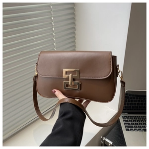 Close-up of brown faux leather shoulder bag featuring a gold H-shaped metal buckle detail