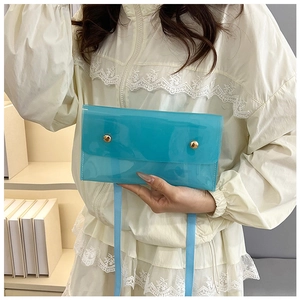 Detail einer hellblauen durchsichtigen PVC-Umschlagtasche mit goldfarbenen Metallnieten