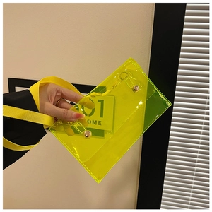 Detailansicht der transparenten neongelben PVC-Schultertasche mit Druckknöpfen und Gurt