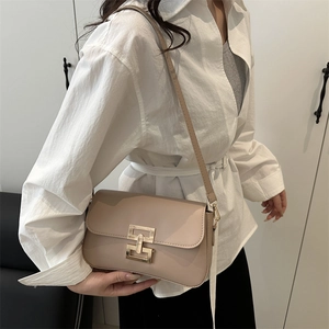 Minimalist beige leather crossbody square bag with unique gold metallic buckle closure