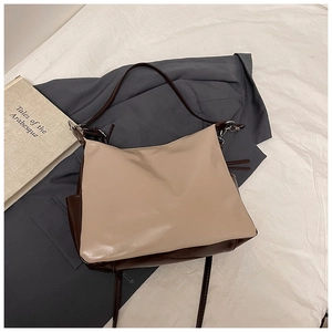 Detail of a large capacity two-tone tote bag in beige and brown faux leather material
