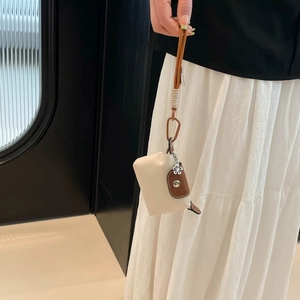 Mini nylon tasje in crèmewit en bruin met leren koord en bloemenbedeltje voor kleine items