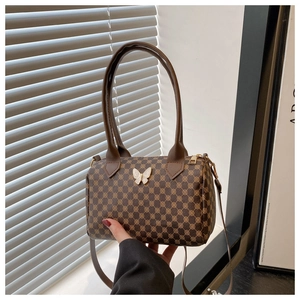 Vue détaillée d'un sac baril marron avec motif vintage et boucle en forme de nœud blanc