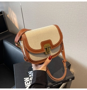 Détail du sac selle rétro en toile avec garniture en cuir marron et coutures contrastées