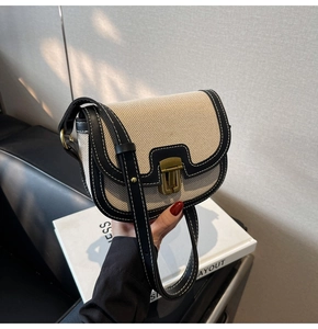 Gros plan des coutures contrastées sur le sac selle en toile beige et cuir noir