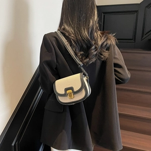 Sacoche rétro en toile avec garniture en cuir noir et boucle dorée sur le mannequin