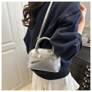 Silver metallic mini Boston bag with mirror finish shown on a model's shoulder