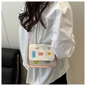 Detail shot of a white and pink crossbody bag featuring marble patterns and cute prints