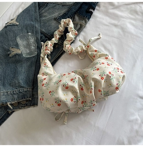 Detail of floral pattern on cream cotton bag with ruched elastic shoulder strap design