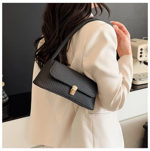 Fashionable black woven shoulder bag featuring a gold square lock and minimalist strap