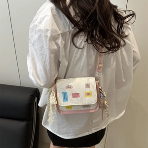 Pink and white crossbody bag with marble pattern flap and colorful patches on model