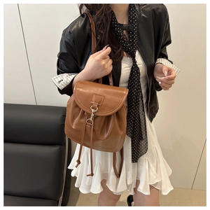 Close-up of retro brown leather backpack for women with metal clasp and flap design
