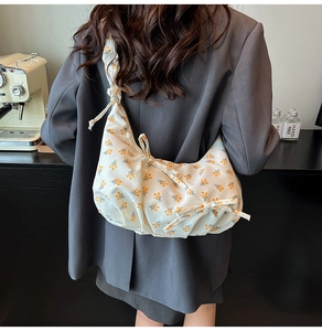 Detailed macro view of the floral print pattern and soft fabric texture on the shoulder bag