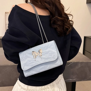 Sac à bandoulière en cuir plissé bleu clair avec fermoir papillon argenté et chaîne