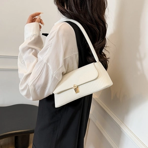 Elegant white leather baguette shoulder bag with gold clasp shown on a female model