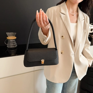 Chic black woven shoulder bag for women with gold square buckle in stylish urban setting