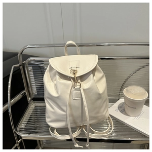 Detail of cream leather backpack with drawstring closure and gold metal buckle lock