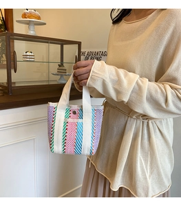 Macro detail of the colorful striped woven tote bag with silver metal buckle and sturdy handles