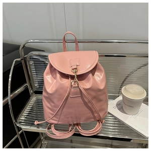 Close-up of pink PU leather mini backpack with gold metal buckle on a metal chair