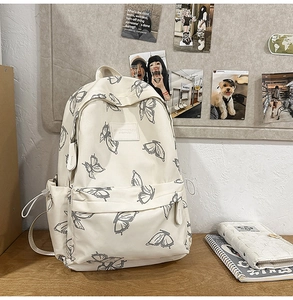 Detail view of cream butterfly backpack showing practical side pockets and fabric texture