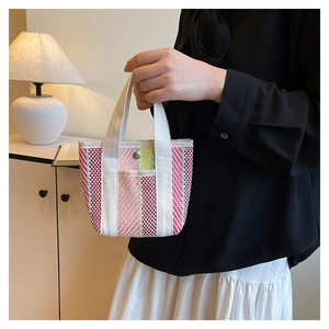 Close-up of woven mini tote bag in colorful stripes with silver snap and white handles