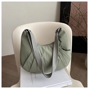 Detailed texture of bean green crescent bag with grey woven wide shoulder strap