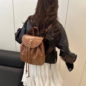 Minimalist brown faux leather backpack with gold metal clasp for travel and daily use