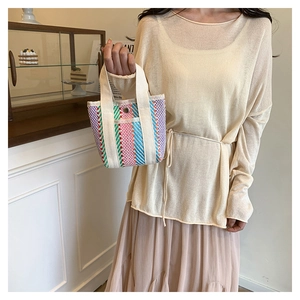 Close-up of colorful striped woven mini tote bag with canvas handles and metal snap closure