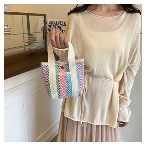 Detailed shot of a striped knit tote bag with cotton handles and metal snap closure