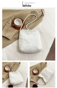 Detail view of white lace tote bag with floral patterns and gold hardware accents