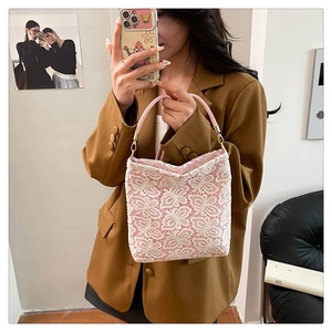 Detail of floral lace texture and pink handles on a high-capacity tote bag for women