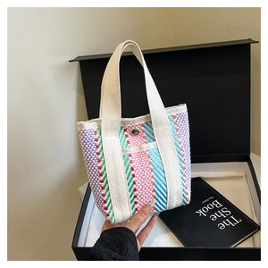 Close-up of colorful striped woven tote bag with silver magnetic snap and cream handle
