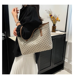 Détail du sac cabas imprimé avec fermoir nœud doré et bandoulières en cuir marron