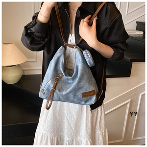 Detail of vintage blue large tote bag with brown leather strap and mini coin purse charm