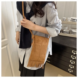 Brown suede crossbody bag featuring long fringe tassels on a minimalist rectangular body