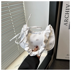 Détail du sac demi-lune blanc avec imprimés chats et poignée plissée avec rubans
