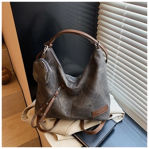 Detail of dark grey tote bag with vintage texture, leather handles and metallic zipper