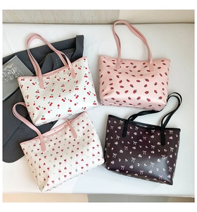 Flat lay of tote bags featuring cherry, strawberry, bear, and bow prints with shoulder straps