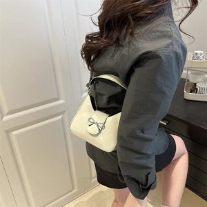 Sac à épaule blanc crème avec boucle argentée et bandoulière en cuir sur modèle