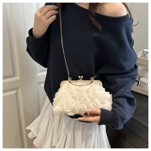Dettaglio della pochette a rosa 3D bianca con catena dorata indossata da una modella