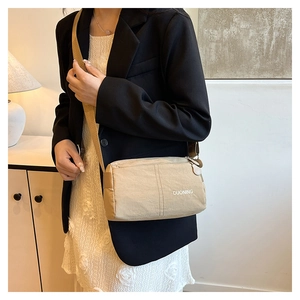 Detail of light khaki crossbody bag with adjustable strap and DUONING logo print