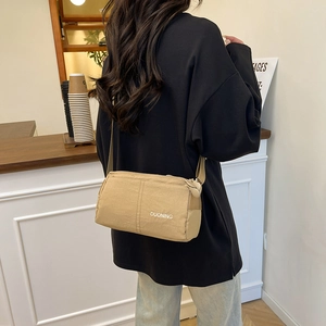 Versatile beige nylon crossbody bag for women featuring adjustable strap and spacious design