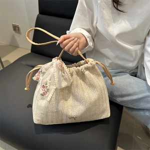 Chic cream woven bucket tote bag with floral lace scarf and metal bow accent