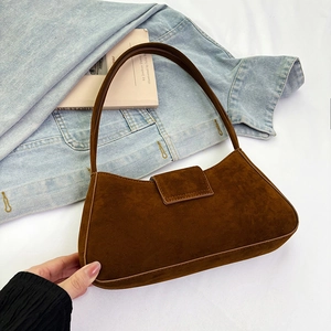 Detail of dark brown suede baguette bag with flap closure and stitching accents